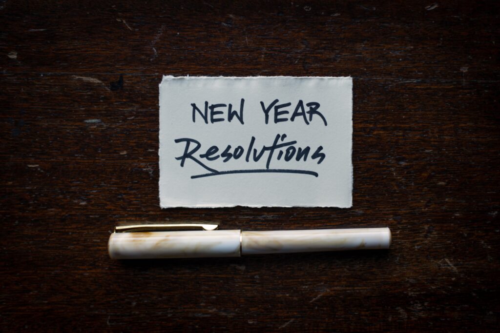 Pen and paper with the words New Year Resolutions